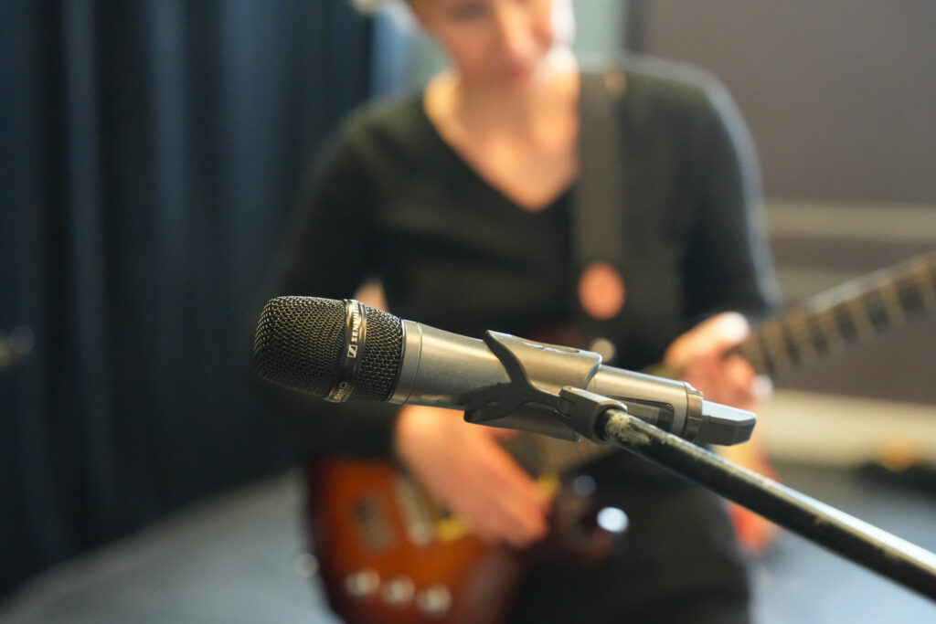 Femme jouant de la guitare devant un micro